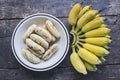 Ripe grilled banana dish and a hand of bananas on black floor Royalty Free Stock Photo