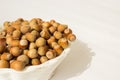 Ripe hazelnuts in a peel on a white background