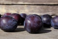 Ripe home plums on a wooden background in the garden. natural healthy vegan food