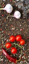 Red hot chili peppers, cherry tomatoes, aromatic garlic, allspice peas and lettuce leaves on a wooden background. Royalty Free Stock Photo