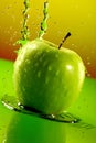 Ripe juicy apple with splashes of drops of water or juice on a green background, Generative AI Royalty Free Stock Photo