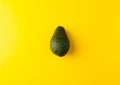 Ripe juicy avocado isolated on a yellow solid background. Vegan, vegetarian, raw food theme.