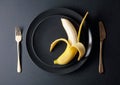 Ripe juicy banana on a black plate Royalty Free Stock Photo