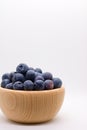 Blueberries in wooden bowl on white background Royalty Free Stock Photo