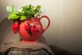 Ripe juicy berries and jug on piece of wood