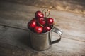 Ripe and juicy cherries in old metal cup on the dark rustic background Royalty Free Stock Photo