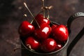 Ripe and juicy cherries in old metal cup on the dark rustic background Royalty Free Stock Photo