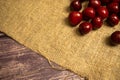 Ripe juicy cherries scattered on a homespun fabric with a rough texture. Close up