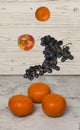 fresh flying orange tangerines apples grape on wooden table