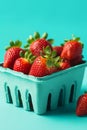 Ripe juicy fresh strawberries in a blue carton on turquoise background. Summer berries healthy lifestyle farmers market produce Royalty Free Stock Photo