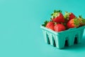 Ripe juicy fresh strawberries in a blue carton on turquoise background. Summer berries healthy lifestyle farmers market produce Royalty Free Stock Photo