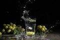 Ripe juicy grapes and glass of water with splashes on dark background Royalty Free Stock Photo
