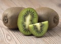 Ripe juicy kiwi fruit with sliced segments on wooden background Royalty Free Stock Photo