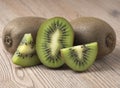 Ripe juicy kiwi fruit with sliced segments on wooden background Royalty Free Stock Photo