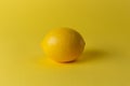 Ripe juicy lemons, orange and green leaves on bright yellow background. Lemon fruit, citrus minimal concept, vitamin C. Creative Royalty Free Stock Photo