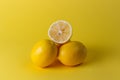 Ripe juicy lemons, orange and green leaves on bright yellow background. Lemon fruit, citrus minimal concept, vitamin C. Creative Royalty Free Stock Photo