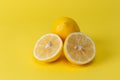 Ripe juicy lemons, orange and green leaves on bright yellow background. Lemon fruit, citrus minimal concept, vitamin C. Creative Royalty Free Stock Photo