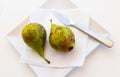 Ripe and juicy pears on plate, served with fork and knife Royalty Free Stock Photo