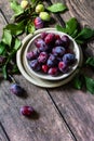 Ripe juicy plums in a bowl on a wooden background. Royalty Free Stock Photo