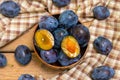 Ripe juicy plums in a wooden bowl. Juicy fruits on a wooden background. Royalty Free Stock Photo