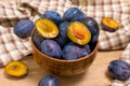 Ripe juicy plums in a wooden bowl. Juicy fruits on a wooden background. Royalty Free Stock Photo