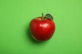 Ripe juicy red apple with leaf on green background Royalty Free Stock Photo