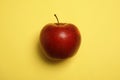 Ripe juicy red apple on yellow background Royalty Free Stock Photo