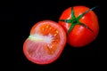 Ripe juicy red tomato with green leaves on a dark background. On tomatoes water drops, clean. Royalty Free Stock Photo