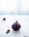 Ripe juicy single fig on a white table near the window. Morning light Royalty Free Stock Photo