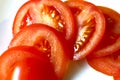 Ripe and juicy tomatoes sliced on a white plate Royalty Free Stock Photo