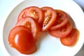 Ripe and juicy tomatoes sliced on a white plate Royalty Free Stock Photo