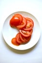 Ripe and juicy tomatoes sliced on a white plate Royalty Free Stock Photo