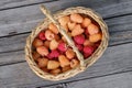 ripe juicy yellow and red raspberries in a wicker basket on a wooden table Royalty Free Stock Photo