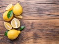 Ripe lemons and lemon leaves on wooden background. Top view. Royalty Free Stock Photo