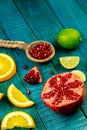 Ripe lime, orange, pomegranate fruit on wooden vintage background. Royalty Free Stock Photo