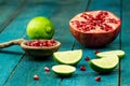 Ripe lime, pomegranate fruit on wooden vintage background. Royalty Free Stock Photo