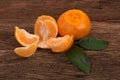 Ripe Mandarin fruit with leaves and one peeled open Royalty Free Stock Photo