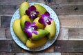 The ripe mango barracuda with decorate the dendrobium orchid flower on the plate Royalty Free Stock Photo