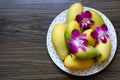 The ripe mango barracuda with decorate dendrobium orchid flower on the plate Royalty Free Stock Photo