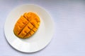 Ripe mango diced on a white plate. Copy space.