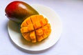 Ripe mango diced on a white plate. Copy space.