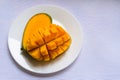Ripe mango diced on a white plate. Copy space.