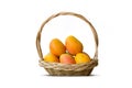 Ripe mangoes in wooden basket isolated white background
