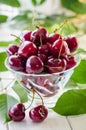Ripe maroon cherries in a glass vase and a jar Royalty Free Stock Photo