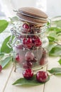 Ripe maroon cherries in a glass vase and a jar Royalty Free Stock Photo