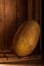 Ripe melon in a wooden box. Photo of a melon in a low key
