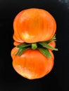 Ripe orange beefsteak tomato on black Royalty Free Stock Photo