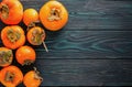 Ripe, orange, juicy persimmons on a wooden old, textured background. Top view. Flat lay