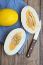 Ripe Organic Fresh Melon Whole and Cut in Half on Blue Napkin Knife on Plank Wood Garden Table. Summer Vitamins