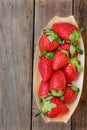 Ripe organic strawberries in birchbark bowl on dark wood background, top view, summer, healthy food